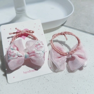 Détail du lot de chouchous avec nœud floral rose et tulle sur carte en forme de cœur