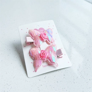 Pink sequin butterfly hair clips set with fabric roses on a white fashion card
