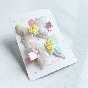 Detail of handmade butterfly hair clips with sequins, fabric roses, and lace mesh
