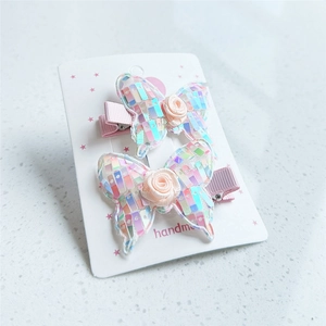 Detail of handmade butterfly hair clips with sequins, silk roses and grosgrain ribbon