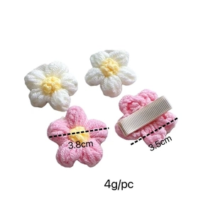 Detailansicht der handgehäkelten Puff-Blumen-Haarclips in Weiß und Rosa aus Garn