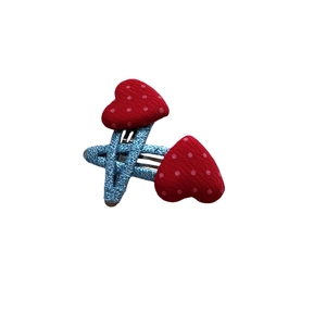 Détail de pinces à cheveux coeur rouge à pois avec revêtement en tissu tissé bleu clair