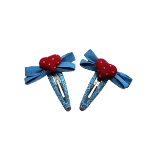 Détail de barrettes coeur en denim bleu avec pois rouges et base pailletée bleue