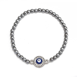 Close-up of hematite beaded bracelet featuring a sparkling evil eye charm and white crystals
