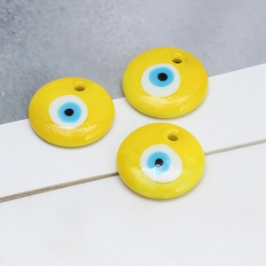 Detailweergave van drie gele boze oog keramische kralen voor DIY sieraden maken en hangers