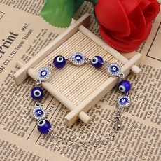 Macro detail of silver alloy Evil Eye beaded bracelet with blue zircon accents