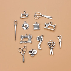 Macro view of vintage silver sewing pendants like scissors and sewing machines