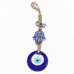 Dettaglio della mano di Hamsa e occhio blu in vetro con corda intrecciata