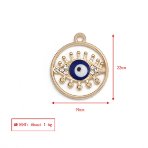 Dettaglio pendente malocchio dorato 19mm con smalto blu e strass scintillanti