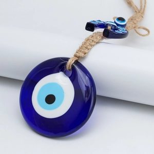 Dettaglio dell'amuleto Evil Eye in vetro con corda di canapa e elemento a ferro di cavallo