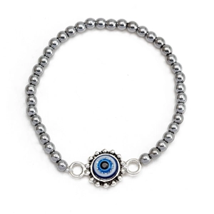 Detailed view of evil eye charm with metallic silver beads on a minimalist bracelet
