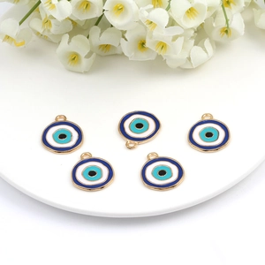 Detail of five evil eye enamel charms on a white plate with floral background decoration