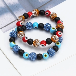 Detail of beaded evil eye bracelet set with blue rhinestones and matte black beads