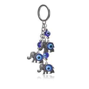 Detail of silver elephant keychain featuring blue evil eye charms and ethnic style beads