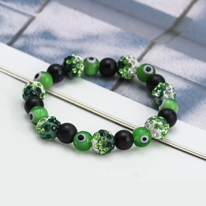 Close-up of green evil eye beads and black matte stones on a beaded bracelet