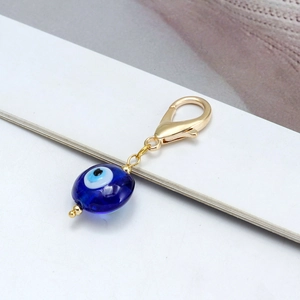 Détail du pendentif œil porte-bonheur en verre bleu avec fermoir mousqueton doré poli