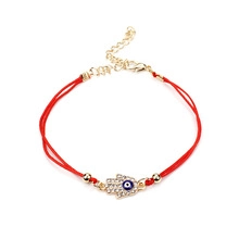 Hamsa Hand and Evil Eye charm on red rope bracelet with adjustable gold chain