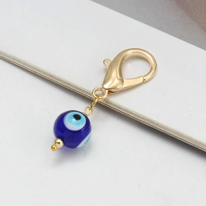 Vue détaillée du pendentif œil maléfique en verre bleu avec un grand fermoir doré