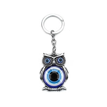 Detailed silver owl keychain charm with blue evil eye nazar beads on white background