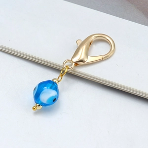 Détail du pendentif Evil Eye en verre bleu avec des finitions dorées élégantes