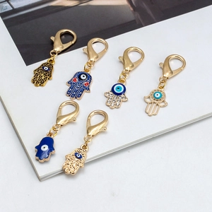 Détail des pendentifs Main de Fatma et Œil Bleu plaqués or avec émail bleu élégant