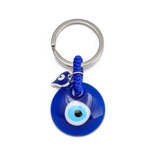 Macro detail of blue glass evil eye nazar pendant with woven nylon rope and silver key ring
