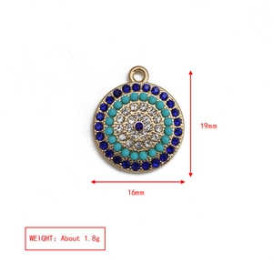 Dettaglio di un ciondolo occhio del diavolo dorato da 16mm con cristalli blu