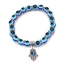 Detailed view of blue evil eye bead bracelet with silver Hamsa hand pendant charm