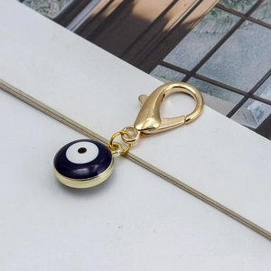Détail du fermoir mousqueton doré avec pendentif perle mauvais œil bleu foncé élégant