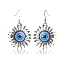 Detail of silver evil eye sunburst earrings with blue inlay and fish hook wires