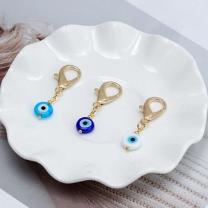 Trois pendentifs œil bleu avec perles en verre et fermoirs mousquetons dorés