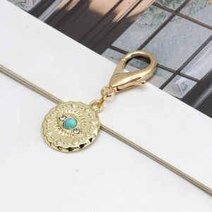 Vue détaillée du fermoir mousqueton doré avec pendentif œil turquoise et strass blancs