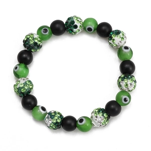 Macro detail of elastic evil eye bead bracelet with green crystals and matte black beads