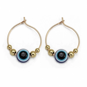 Detailed close-up of golden hoop earrings featuring blue evil eye beads and gold accents
