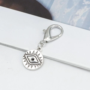 Detailed close-up of a silver Evil Eye charm with lobster clasp on a clean white card