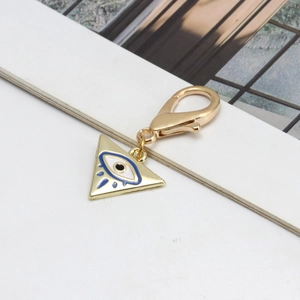 Vue macro du pendentif triangle Œil Bleu en plaqué or avec émail bleu et fermoir mousqueton