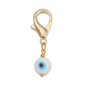 Détail du fermoir mousqueton doré avec pendentif œil grec en verre sur fond blanc