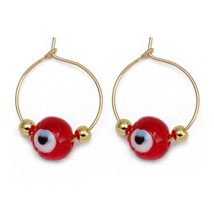 Detailed close-up of red beads with evil eye pattern on golden hoop earrings