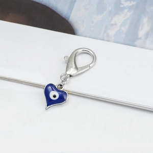 Detailed macro of a blue heart-shaped evil eye pendant with a silver lobster clasp