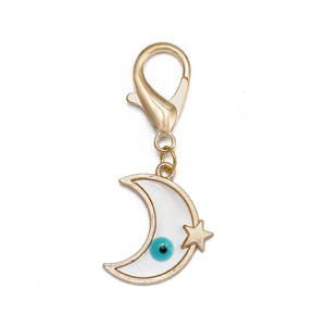 Détail du pendentif lune dorée avec perle d'œil bleu et petite étoile suspendue