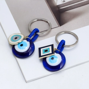 Detailed macro view of Evil Eye charms with blue glass finish and woven cord keychains
