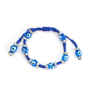 Macro detail of hand-woven blue Evil Eye bracelet with sparkling rhinestone-set alloy beads