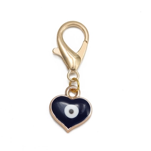 Détail du pendentif Œil Maléfique en forme de cœur avec fermoir mousqueton doré sur blanc