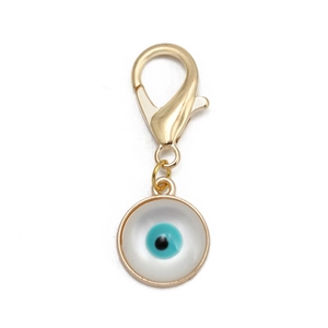 Gros plan détaillé d'un fermoir mousqueton doré avec pendentif œil bleu sur fond blanc