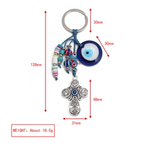Detailed view of evil eye and silver cross keychain charm with precise dimensions