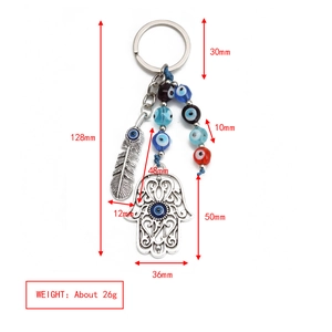 Macro view of blue evil eye beads and silver Hamsa hand charm on a metal keychain