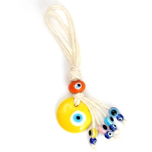 Detail of hand-woven Evil Eye hanging ornament featuring a yellow glass pendant and beads