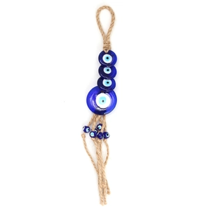 Detailed close-up of handmade evil eye pendant with blue glass beads and jute rope tassels