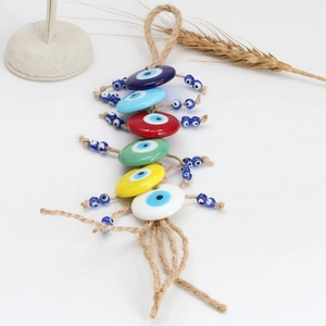 Detailed close-up of Bohemian evil eye wall hanging with colorful glass beads and jute rope