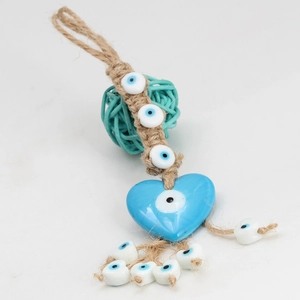 Detail of handmade evil eye charm with blue heart glass bead and hemp rope weaving